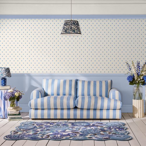 Room decorated with Button Spot Blue wallpaper, featuring playful blue polka dots on a cream background