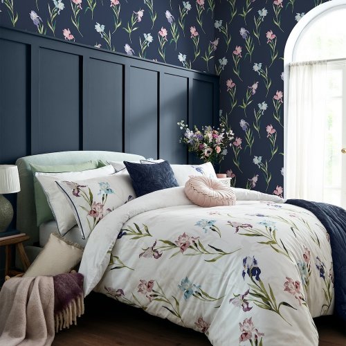 Bold floral wallpaper featuring green stems and colorful irises on a midnight blue background.