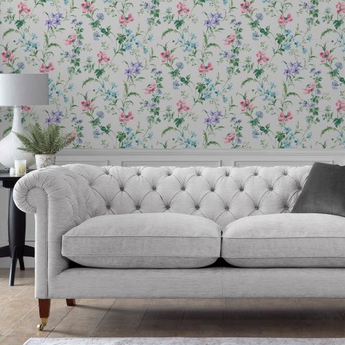 English meadow-inspired wallpaper featuring pink, blue, and purple poppies against a soft violet backdrop.